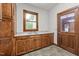 Laundry room featuring wooden cabinetry, sink, and tile flooring at 4070 Swannie Coble Rd, Snow Camp, NC 27349
