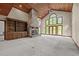 Open-concept living room with a stone fireplace, built-in shelves, and large windows at 4070 Swannie Coble Rd, Snow Camp, NC 27349