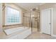 Bright bathroom with soaking tub, glass enclosed shower, and natural light at 4517 Gates St, Raleigh, NC 27609