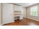 Bedroom with hardwood floors, a built-in desk with drawers and cabinets, and a window at 4517 Gates St, Raleigh, NC 27609