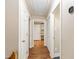 Hallway with hardwood floors, thermostat on wall, and multiple doorways at 4517 Gates St, Raleigh, NC 27609