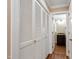 Hallway with hardwood floors and louvered closet doors leading to a bathroom at 4517 Gates St, Raleigh, NC 27609