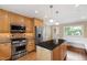 Updated kitchen with stainless steel appliances and island with black countertop at 4517 Gates St, Raleigh, NC 27609