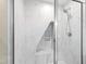 The shower features marble tiling and a built-in shelf space at 4517 Gates St, Raleigh, NC 27609