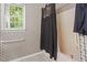 This bathroom features a shower tub combo with floral wallpaper and a white trim window at 5105 Baywood Forest Dr, Knightdale, NC 27545