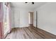 Bedroom with wood laminate flooring, window with pink curtains and an open door at 5105 Baywood Forest Dr, Knightdale, NC 27545