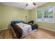 Bedroom featuring ceiling fan and large window looking into a fenced back yard at 5105 Baywood Forest Dr, Knightdale, NC 27545