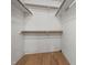 An empty closet with white walls, wood shelving and flooring provides ample storage at 5105 Baywood Forest Dr, Knightdale, NC 27545