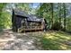 A two-story house with dark siding and backyard space with a wooden deck and lush greenery at 5217 West Oaks Dr, Fuquay Varina, NC 27526