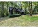 Striking exterior showcasing a home with dark siding, large windows, and a well-manicured lawn at 5217 West Oaks Dr, Fuquay Varina, NC 27526