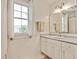 Bright bathroom with white cabinets, a marble countertop, and a large window for natural light at 73 Lynnville Ct, Lillington, NC 27546
