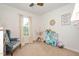 Cozy bedroom featuring a comfortable armchair, a playful play kitchen, and soft natural lighting at 73 Lynnville Ct, Lillington, NC 27546