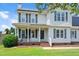 Charming two-story home with solar panels, featuring a welcoming front porch and well-maintained landscape at 73 Lynnville Ct, Lillington, NC 27546