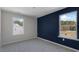 A bedroom featuring a neutral wall color contrasted with a bold blue accent wall and two windows at 813 Old Tarboro Rd, Wendell, NC 27591