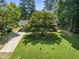 This home boasts a lush front yard with mature trees, a long driveway, and well-maintained landscaping at 908 Clarion Dr, Durham, NC 27705