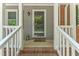 Close-up of the front porch with a decorative door and 'wipe your paws' welcome mat at 908 Clarion Dr, Durham, NC 27705