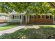 Inviting brick home showcasing a cozy front porch and well-maintained lawn at 908 Clarion Dr, Durham, NC 27705