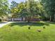 Charming brick home with a well-manicured lawn and mature tree providing shade at 908 Clarion Dr, Durham, NC 27705