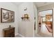 Neutral hallway showcasing decorative paintings, a shelf, and an open doorway to the kitchen at 908 Clarion Dr, Durham, NC 27705