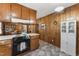 Kitchen features wood paneling, white storage cabinet, and a view into dining room at 908 Clarion Dr, Durham, NC 27705