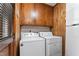 Laundry room with wooden cabinets and modern washing machine and dryer at 908 Clarion Dr, Durham, NC 27705