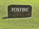 The Foxfire community brick sign sits on a sunny, well-manicured lawn at 101 Creekside Dr, Selma, NC 27576