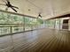 Large outdoor deck with stained wood and ceiling fans overlooking a wooded area at 101 Creekside Dr, Selma, NC 27576