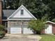 Detached two-car garage with stone accents, white doors, and an upper story window at 101 Creekside Dr, Selma, NC 27576