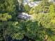 Aerial view of a lush property with beautiful landscaping, a lake, and a well-maintained home at 101 Painted Rock Ct, Garner, NC 27529