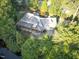 Aerial view showcases a home with lush landscaping, serene pond, and ample space for outdoor living at 101 Painted Rock Ct, Garner, NC 27529