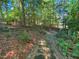 Landscaped backyard featuring a stone walkway with a small wooden bridge in a wooded setting at 101 Painted Rock Ct, Garner, NC 27529