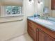 Bathroom with wooden cabinets, granite countertop, large window, and a chrome handrail at 101 Painted Rock Ct, Garner, NC 27529