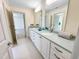 Bathroom with double sinks, white cabinets, grey countertops, and tile floors at 101 Painted Rock Ct, Garner, NC 27529