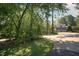 Long driveway leads to a two-story home surrounded by mature trees, providing privacy and charm at 101 Painted Rock Ct, Garner, NC 27529