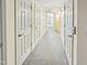Well-lit hallway featuring neutral walls, carpeted floor, and multiple white doors at 101 Painted Rock Ct, Garner, NC 27529