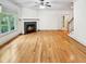 Bright living room featuring a fireplace, hardwood floors, large windows, and a ceiling fan at 101 Painted Rock Ct, Garner, NC 27529