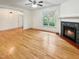 Cozy living room with hardwood floors, fireplace, and a large window providing natural light at 101 Painted Rock Ct, Garner, NC 27529