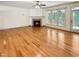 Open living room featuring hardwood floors, fireplace, and access to an outdoor balcony at 101 Painted Rock Ct, Garner, NC 27529