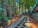 Stone pathway through the yard of wooded home leads to elevated deck at 101 Painted Rock Ct, Garner, NC 27529