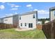 The back of a home shows a fenced backyard, sliding glass doors, and a gravel fire pit area at 1022 Homecoming Way, Durham, NC 27703