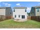 The back of a home shows a fenced backyard, sliding glass doors, and a gravel fire pit area at 1022 Homecoming Way, Durham, NC 27703