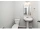 Half bathroom featuring a pedestal sink, toilet, and a silver-framed mirror at 1022 Homecoming Way, Durham, NC 27703