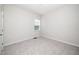 A simple bedroom with neutral walls and carpet features a single window and an air vent at 1022 Homecoming Way, Durham, NC 27703