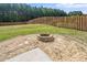 A charming fire pit area in a fenced backyard, surrounded by lush greenery and offering a serene outdoor space at 1022 Homecoming Way, Durham, NC 27703