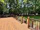 A wooden deck featuring black metal railings, with stairs leading to a lush green backyard at 105 Abbotsford Ct, Durham, NC 27712