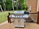 A stainless steel grill sits on a wooden deck with black metal railings, next to a brick home at 105 Abbotsford Ct, Durham, NC 27712