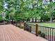 A wooden deck featuring black metal railings, and stairs leading to a lush green backyard at 105 Abbotsford Ct, Durham, NC 27712