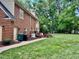 Expansive backyard with lush green grass, mature trees, and a charming brick home at 105 Abbotsford Ct, Durham, NC 27712