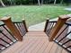 View of a wooden deck with black railings leading down to a green lawn at 105 Abbotsford Ct, Durham, NC 27712