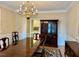 Formal dining area featuring a wooden table, china cabinet, and decorative chandelier at 105 Abbotsford Ct, Durham, NC 27712